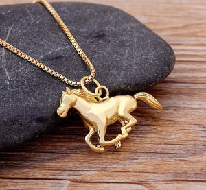 Gold plated horse pendant necklace with a 45cm chain on a wooden background.