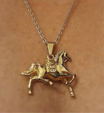 Gold horse pendant necklace with cubic zirconia saddle blanket on stainless steel chain.