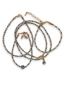 Evil eye beaded necklace matching bracelet set with black beads and gold accents.