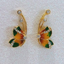 Colourful butterfly gold earrings with clear stones on antennas.