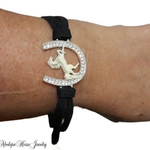 Horse-shoe Bracelet with crystals and rearing horse on black cord.