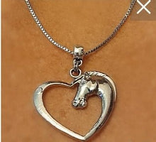 Silver pendant charm necklace with horse head inside a heart on a box chain.