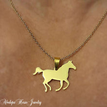 Gold horse cantering necklace with stainless steel pendant and customizable letter charm on a 55 cm gold chain.