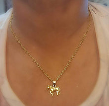 Gold standing pony necklace with gold-plated pendant on model.