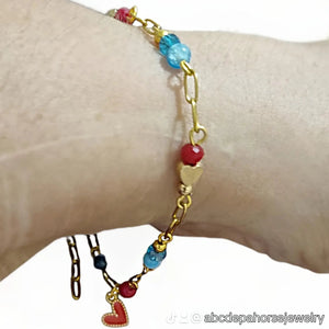 Red coral loveheart bracelet - with gold loveheart charm on wrist.