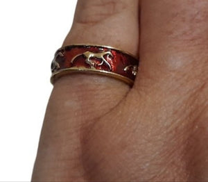 Red Gold Horse Ring - on finger, featuring gold horses on a red-coated band.