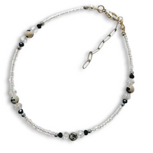 Dalmatian Jasper bracelet with crystal clear bicone beads, gold stainless steel accents, and adjustable chain.