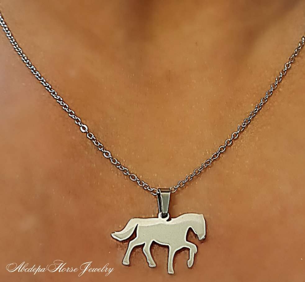 Silver stainless steel walking horse necklace on model.